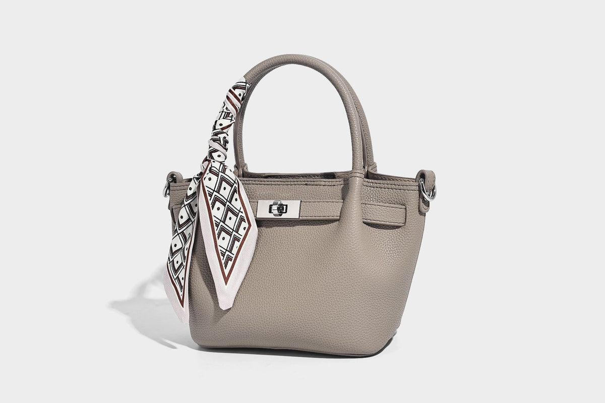 Kleine strukturierte Henkeltasche aus genarbtem Material in Taupe mit zwei Henkeln, bedrucktem Schalband, vorderem Drehverschluss und, Detail