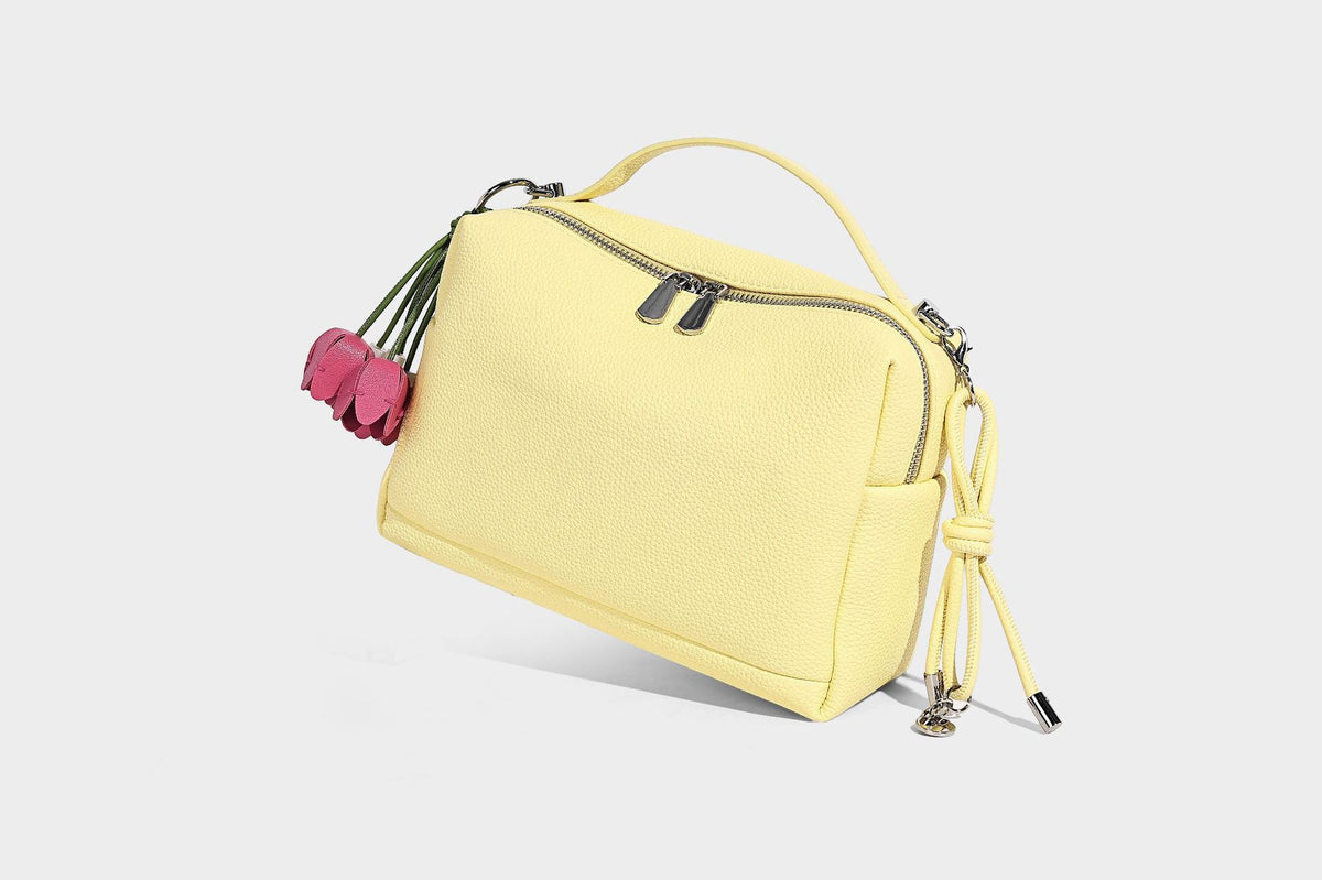 Kleine strukturierte Crossbody-Tasche mit Tragegriff aus genarbtem Material, Reißverschluss, silberfarbenen Beschlägen und optionalem Quastenanhänger