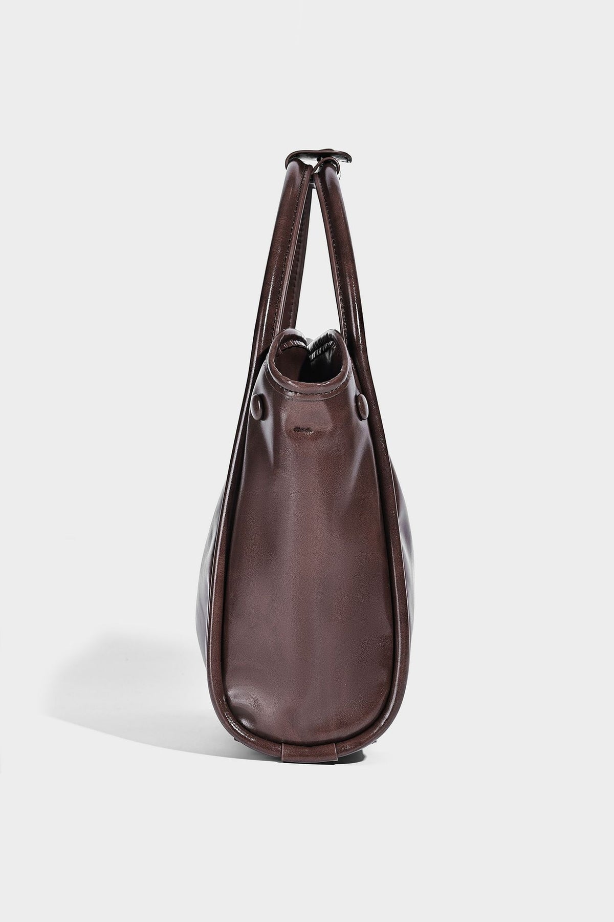 Glossy leather-look structured tote bag with rounded top handles, detachable shoulder strap, embossed front emblem, and side