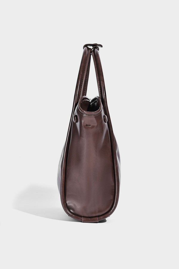 Glossy leather-look structured tote bag with rounded top handles, detachable shoulder strap, embossed front emblem, and side