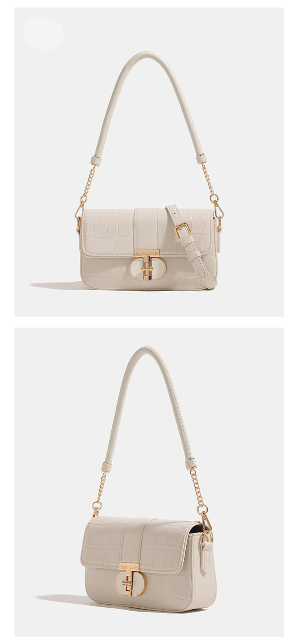 Small crocodile-embossed flap crossbody bag with circular gold turn-lock closure and chain strap, detail view 9