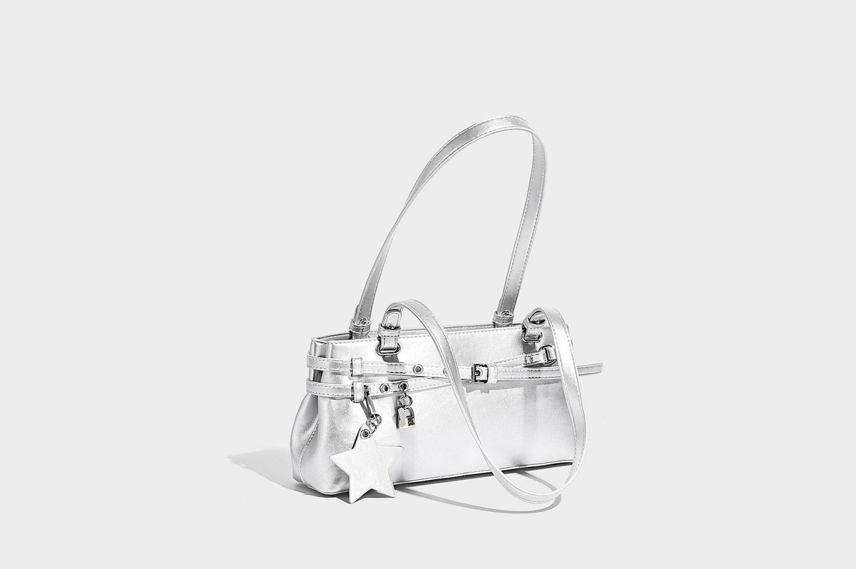 Structured glossy leather-look shoulder bag with wraparound belt straps, silver-tone hardware, and dangling star charm