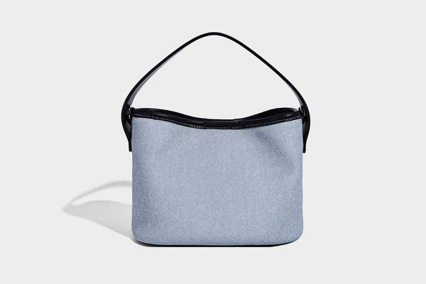 Hellblaue Bucket-Bag aus Denim mit schwarzem Besatz in Lederoptik, silberfarbenen Beschlägen, kurzem Tragegriff und langem verstellbarem Crossbody-Riemen