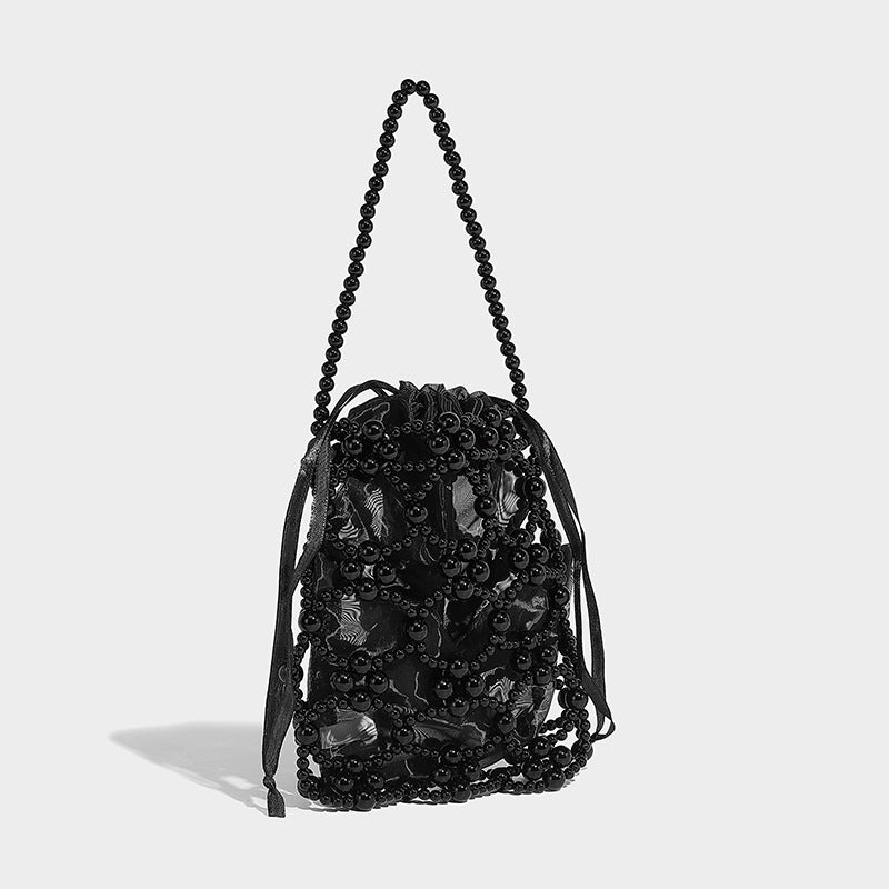 Small pearl-beaded lattice drawstring bucket bag with beaded shoulder strap and ribbon closure, detail view 3