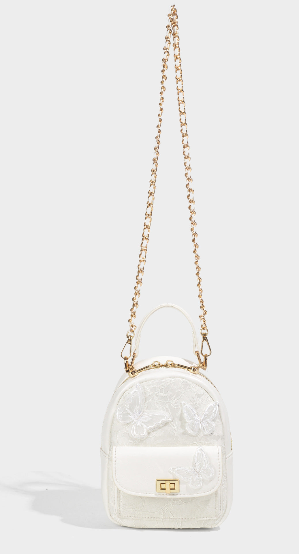 Structured mini backpack handbag with butterfly embroidery, gold-tone chain strap, and turn-lock front flap pocket, detail