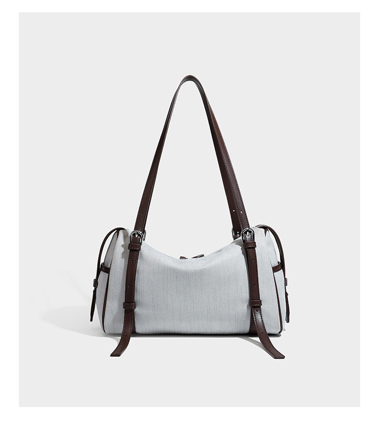 Olivgrüne Schultertasche in Zylinderform aus Canvas mit Riemen in schwarzer Lederoptik, Reißverschluss oben und silberfarbenen Beschlägen, Detailansicht
