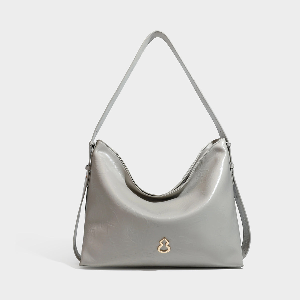 Lässig-sackförmige Hobo-Schultertasche mit offenem oberen Rand in glänzender karamellfarbener Lederoptik, goldfarbenen Logo-Beschlägen und langem verstellbarem