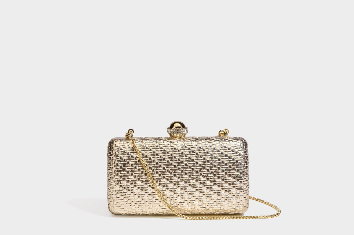 Small structured metallic woven-texture box clutch bag with jeweled kiss-lock dome clasp and slim gold chain strap, detail