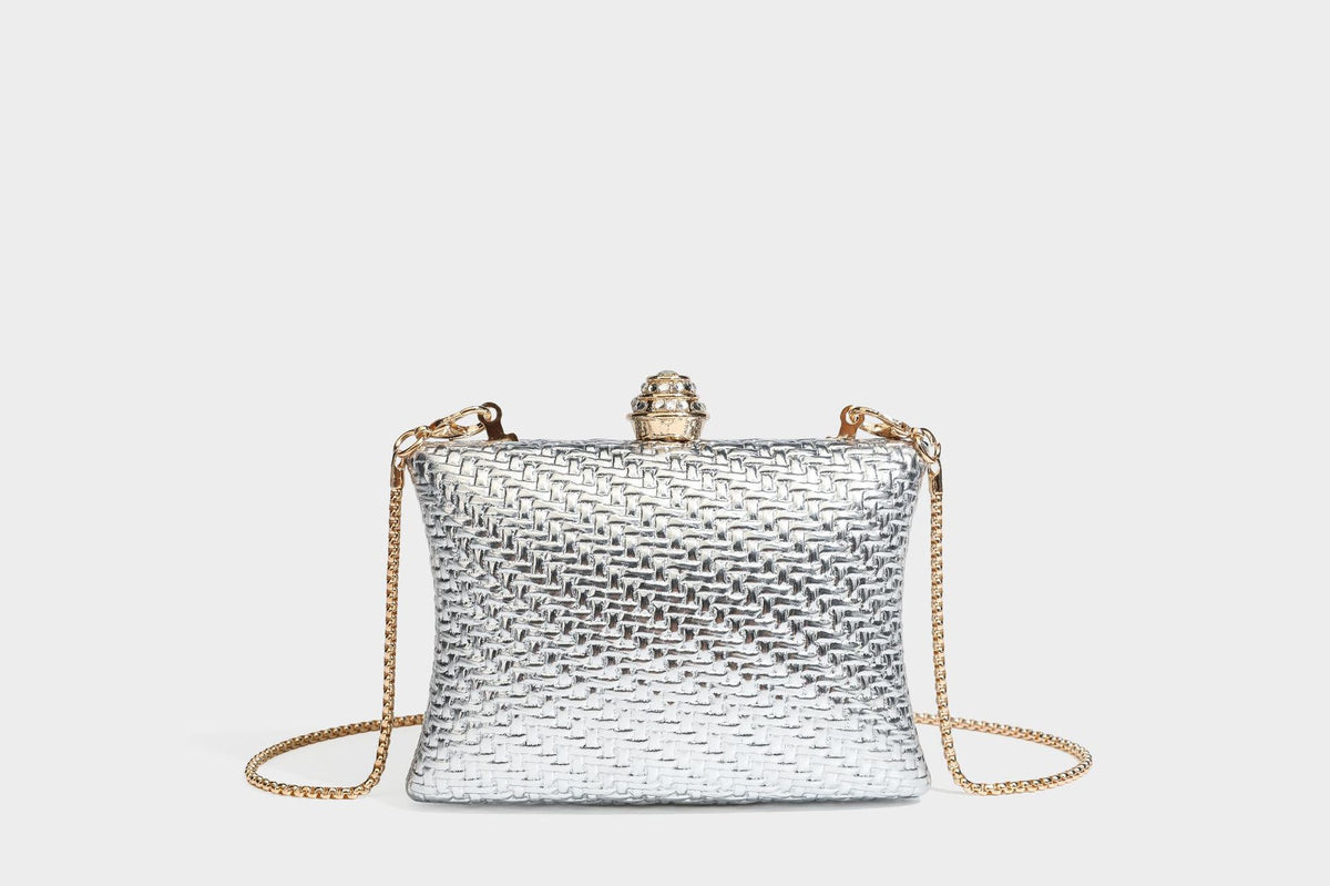 Small structured rectangular metallic woven-texture clutch bag with jeweled knob clasp and gold-tone chain strap, detail view