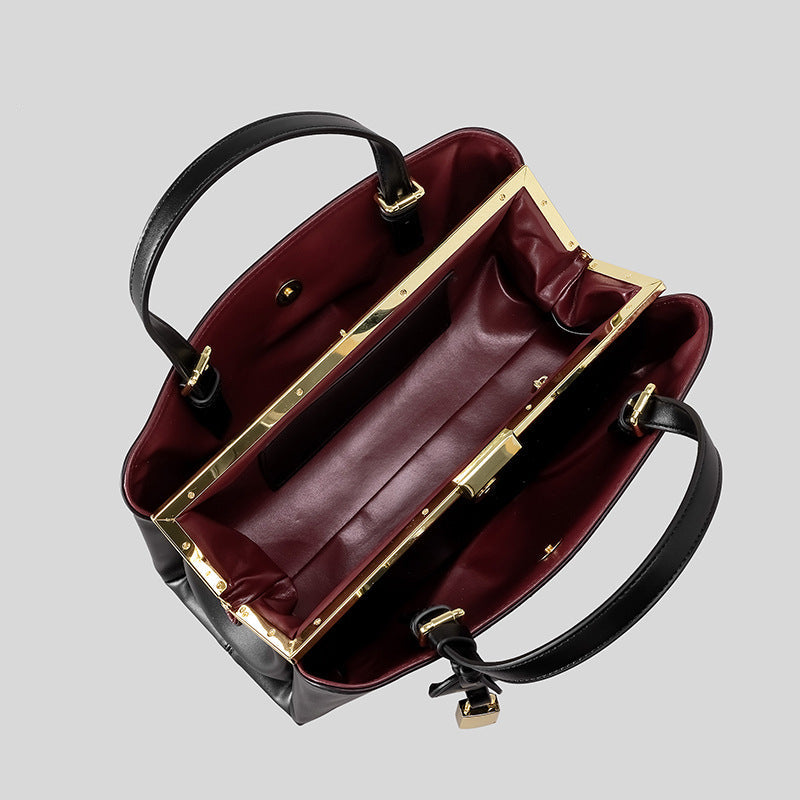 Strukturierte, rechteckige Henkeltasche in Lederoptik mit goldfarbenem Schlossanhänger und bordeauxrotem Innenfutter, Detailansicht 4