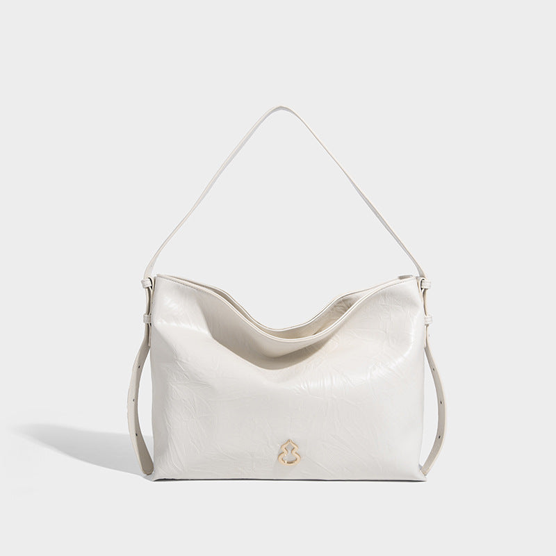 Large slouchy hobo shoulder bag in glossy crinkle leather-look finish with gold-tone emblem hardware and adjustable strap