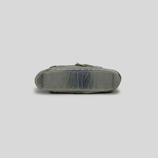 Washed blue-gray denim slouchy hobo shoulder bag with wide grommeted belt panel, brass-tone D-ring buckle, exterior zip