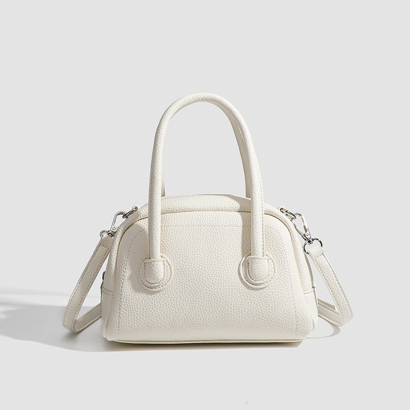 Mini-Boston-Tasche mit genarbter Oberfläche, zwei Tragegriffen, abnehmbarem verstellbarem Crossbody-Riemen und Beschlägen in Silberoptik, Detailansicht