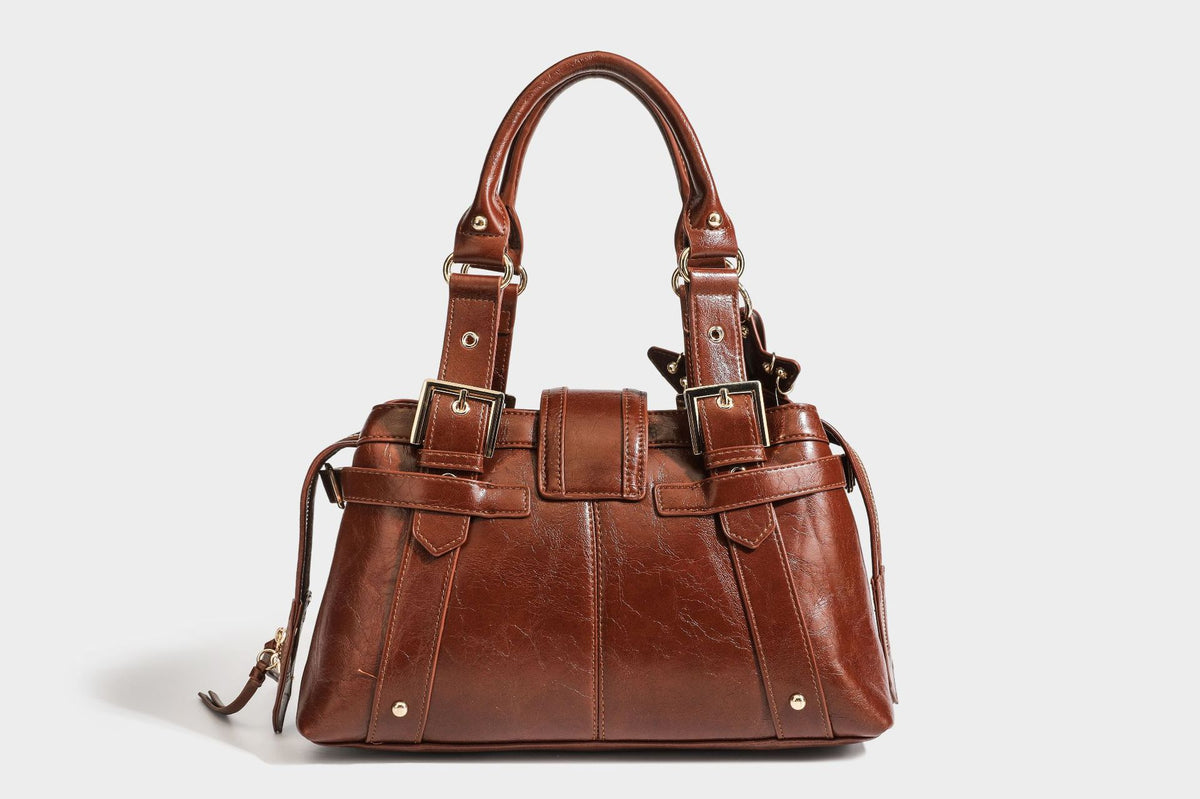 Structured leather-look satchel bag with heart padlock charm, star charm, gold-tone buckle hardware, dual top handles, and
