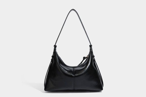 Übergroße, lässig fallende Hobo-Schultertasche aus glänzendem, geknittertem Lederimitat mit goldfarbenem Reißverschluss und Emblem-Beschlägen, Detailansicht