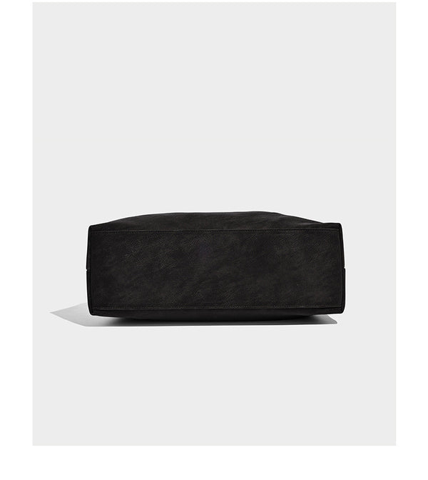 Slouchy oversized shoulder tote bag with matte textured finish, wrap-around buckle strap, and detachable front zip pouch