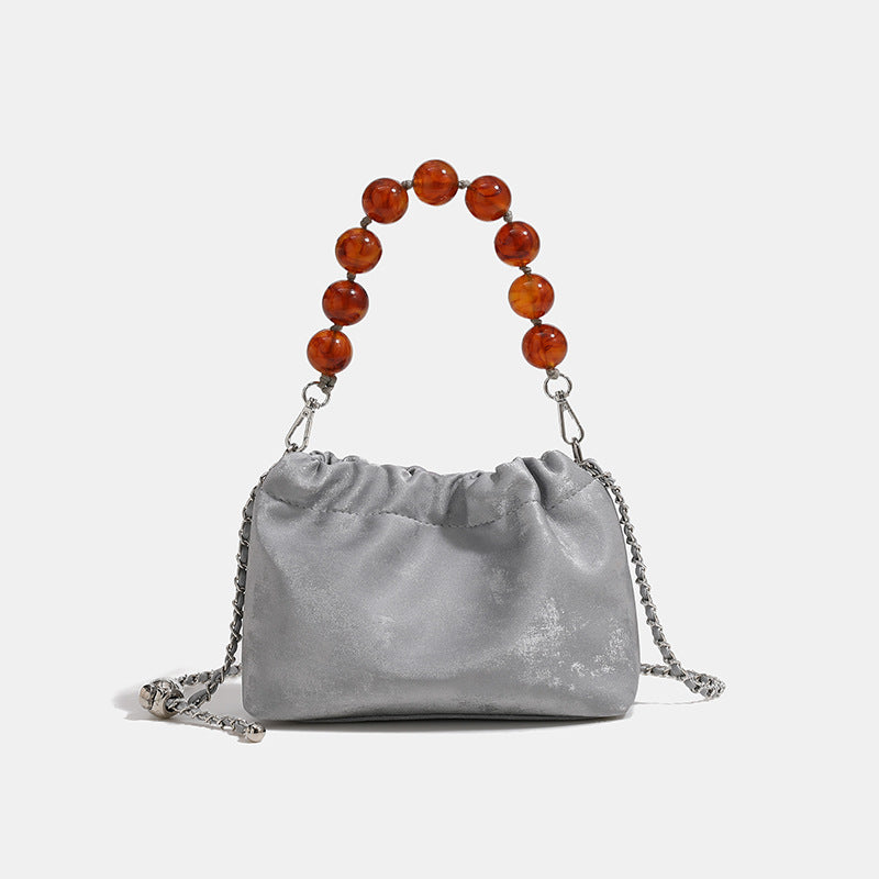 Ruched drawstring bucket bag with amber resin bead handle and silver-tone chain strap, detail view 7