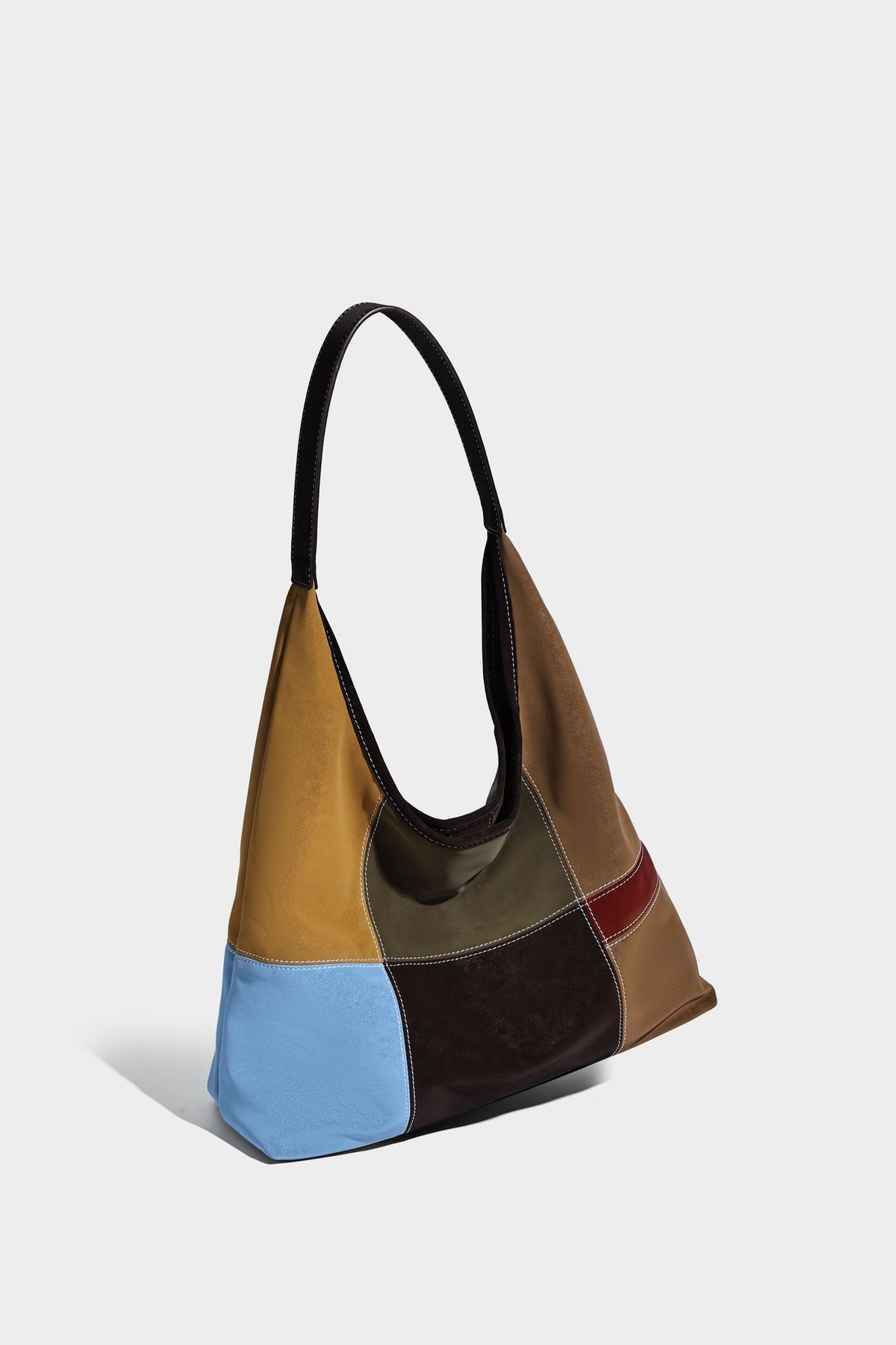 Multicolor patchwork hobo shoulder bag with brown tan olive mustard red and blue suede-look panels, contrast white stitching