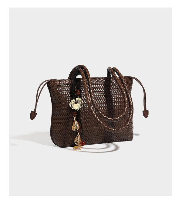 Structured woven leather-look tote bag in dark brown with long shoulder straps, side drawstring ties, and gold filigree