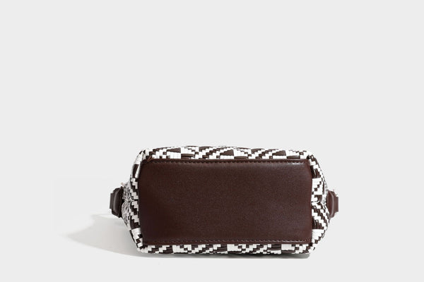 Kleine schwarz-weiße Schultertasche mit gewebtem geometrischem Muster, glatter dunkelbrauner Besatz aus Lederoptik, geknotetem verstellbarem Riemen und seitlichem