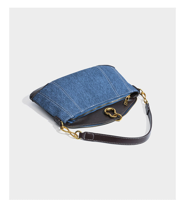 Slouchy denim shoulder bag with dark leather-look trim, gold-tone chain-link hardware, and top zipper closure, detail view 11