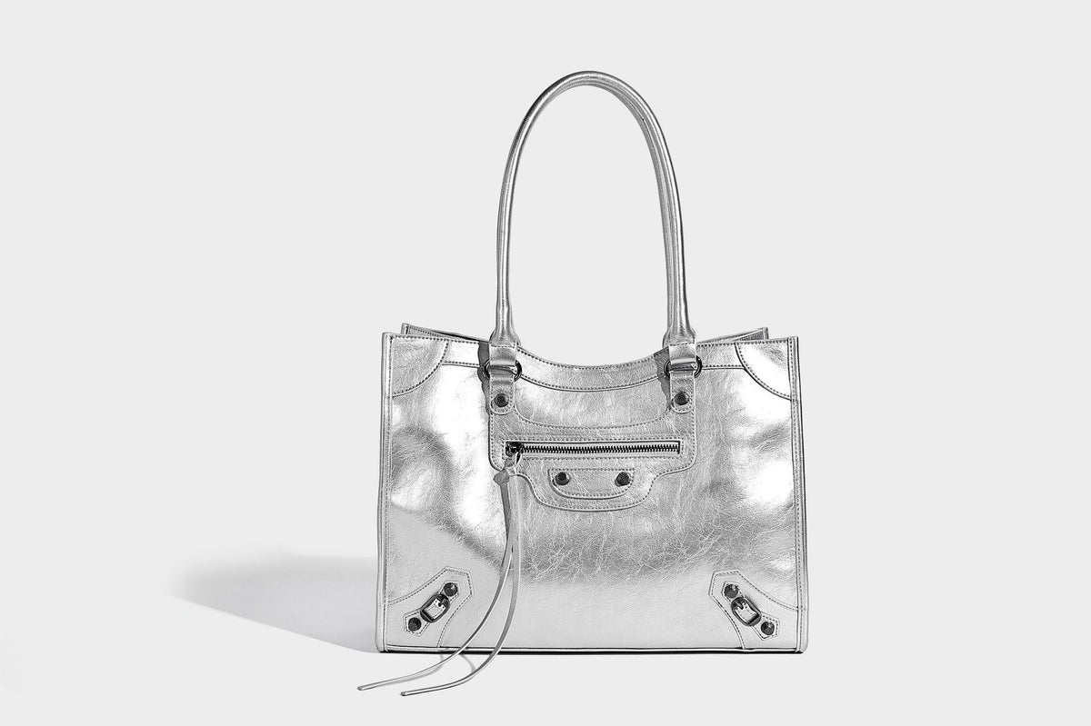 Large structured leather-look tote bag with front zip pocket, moto hardware accents, and long double shoulder straps, detail