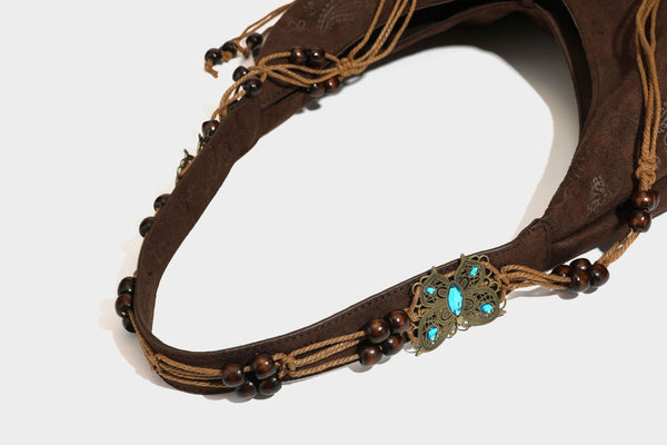 Slouchy boho hobo shoulder bag in embossed brown suede-look finish with beaded strap, cord tassels, and brass-tone leaf