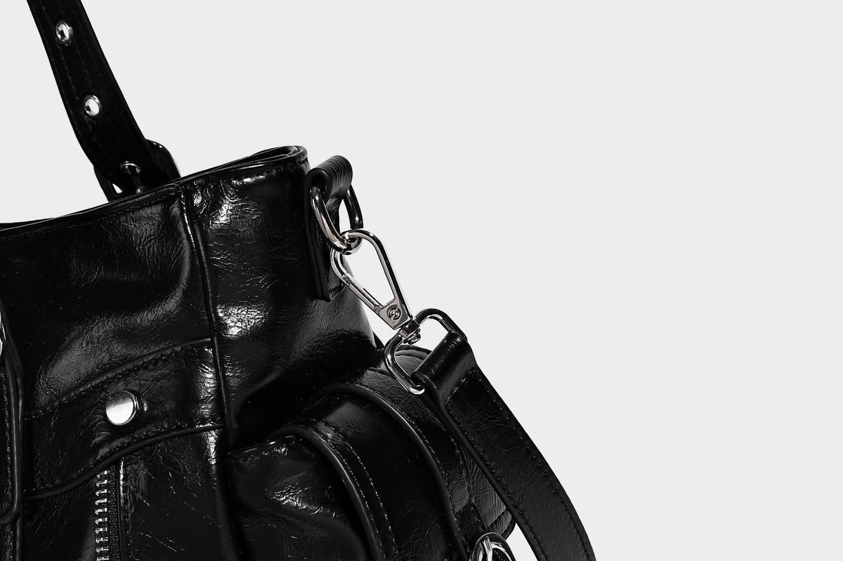 Glossy structured black tote shoulder bag with silver buckle hardware, zip pockets, dual top handles, and detachable, detail