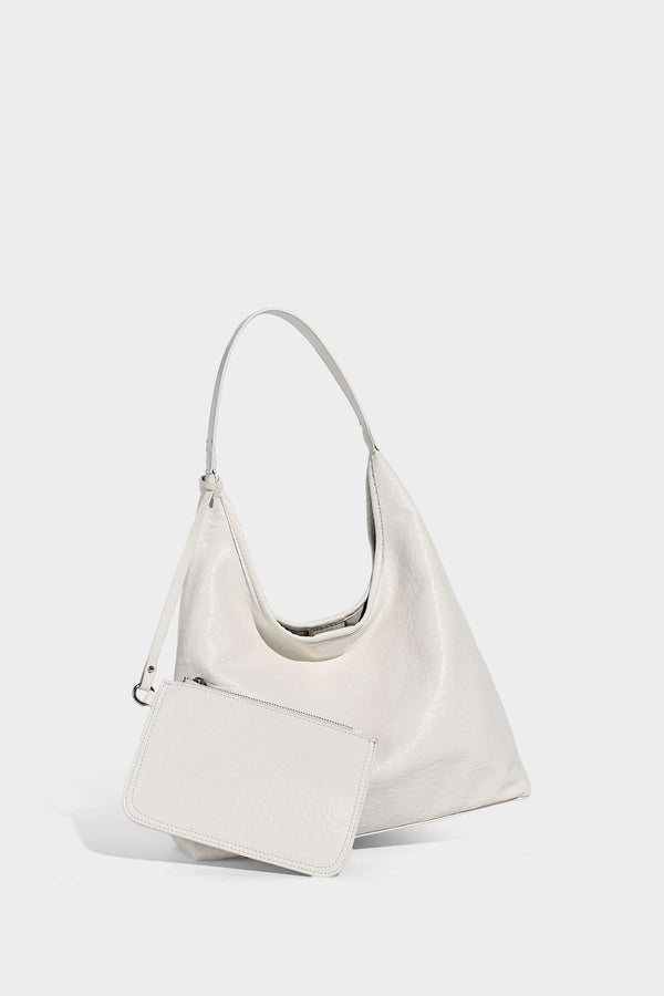 Slouchy hobo shoulder bag in pale yellow glossy pebbled leather-look finish with single shoulder strap and detachable front
