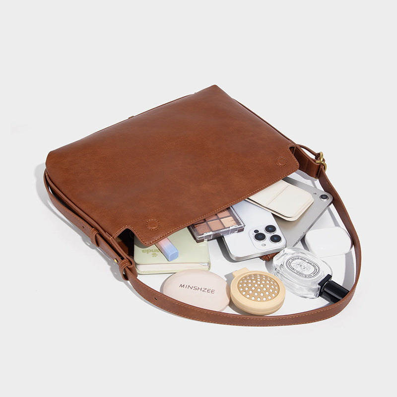 Slouchy brown leather-look shoulder bag with knotted drawcord tie closure, gold-tone ring hardware, and long adjustable