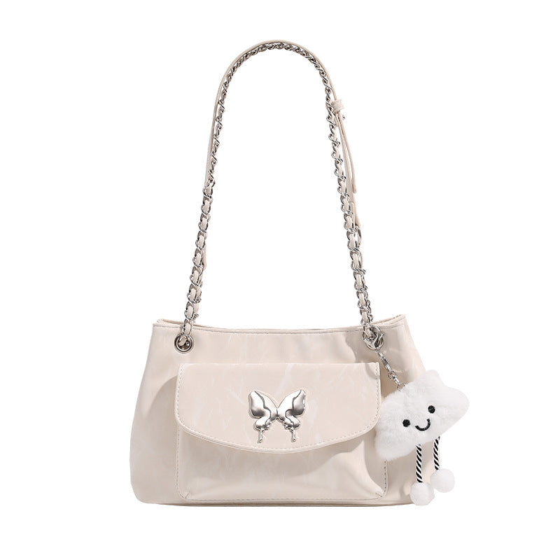 Soft rectangular glossy leather-look shoulder bag with silver chain strap, butterfly ornament on front flap pocket, and