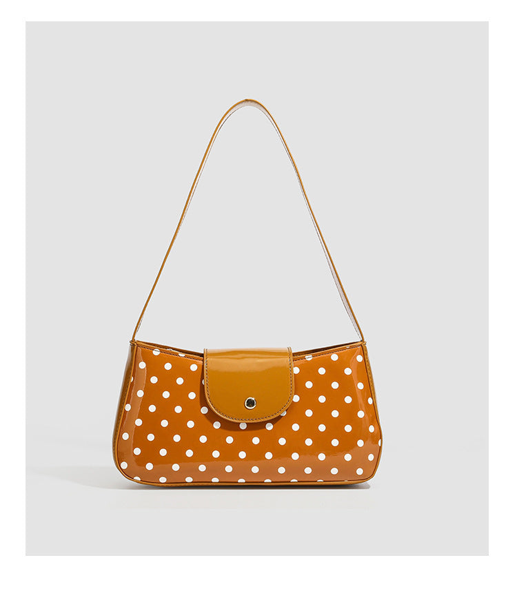 Strukturierte Baguette-Schultertasche mit Tupfenmuster, glänzender Lacklederoptik, Klappe mit Druckknopfverschluss und goldfarbenen Beschlägen, Detailansicht