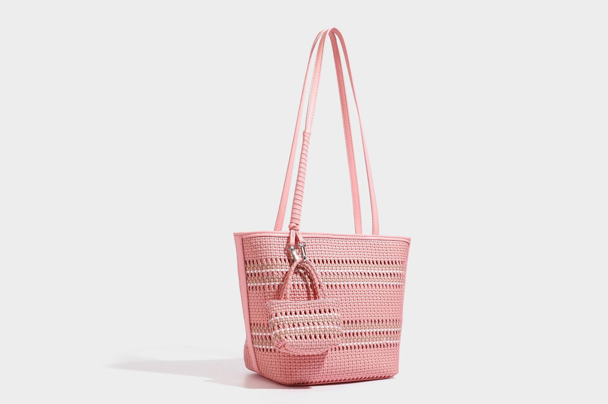 Large structured woven tote bag with striped basket-weave finish, long shoulder straps, and detachable mini pouch charm