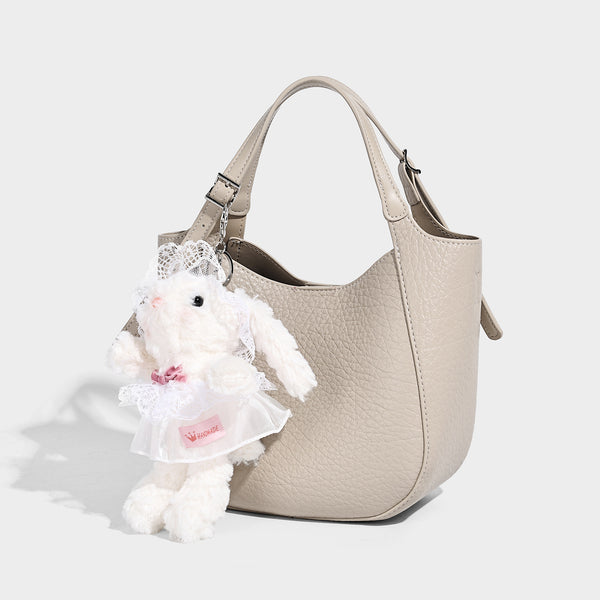 Small pebbled half-moon shoulder bag with dual top handles, detachable crossbody strap, and silver-tone hardware, detail view