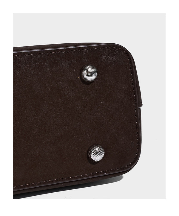 Structured trapezoid shoulder tote in dark brown matte suede-look finish with dual straps, wraparound belt bands