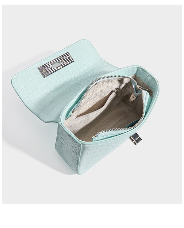 Small structured rectangular satchel with glossy crocodile-embossed finish, arched top handle, front flap, and silver-tone