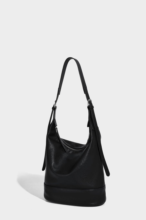 Slouchy bucket hobo shoulder bag in dark brown with glossy leather-look finish, top zip closure, and long adjustable, detail