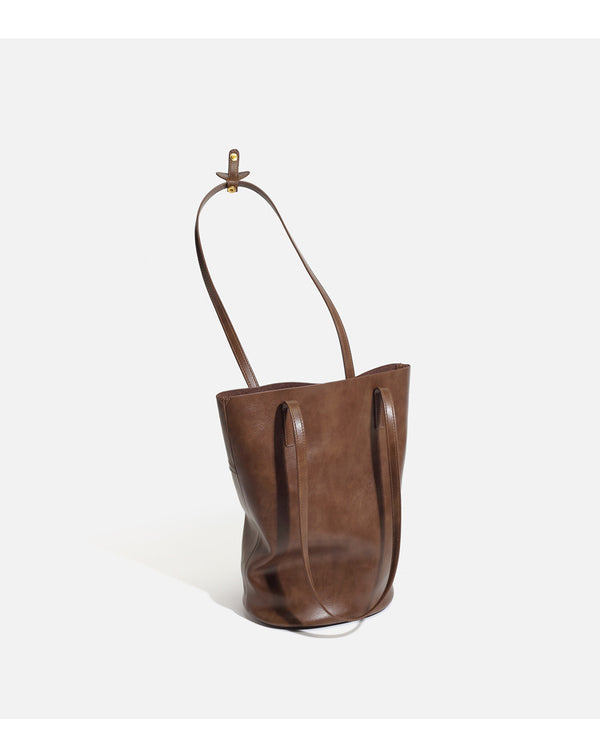 Large black smooth leather-look bucket tote bag with long shoulder straps and open top, detail view 8