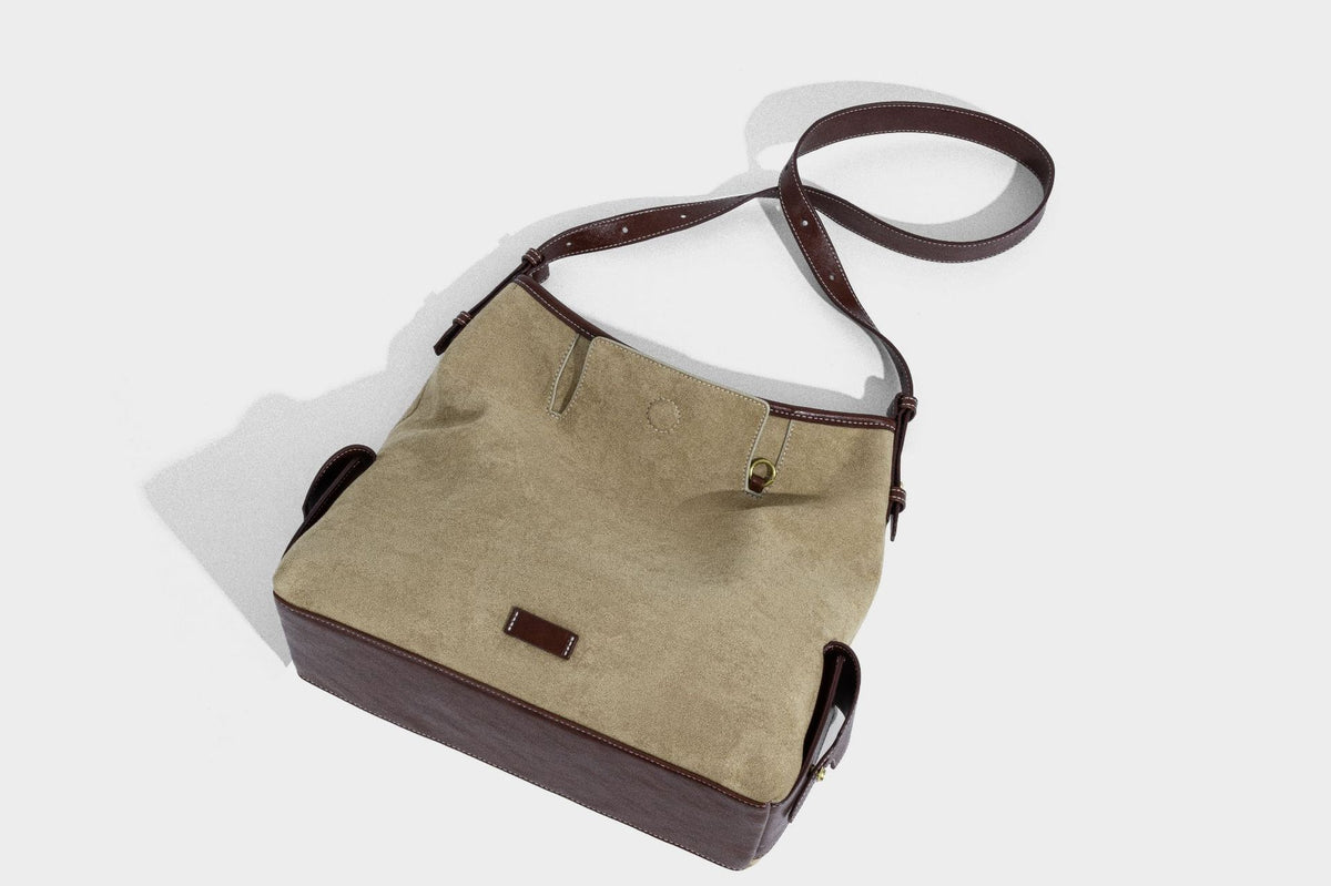 Lässig fallende Hobo-Schultertasche in Khaki aus mattem Material in Wildlederoptik mit dunkelbraunem Besatz in Lederoptik, Quastenanhänger mit Perlen und seitlicher Klappe, Detailansicht