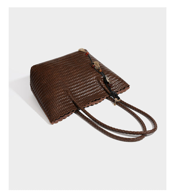 Large open-top woven leather-look tote bag in dark brown with scalloped edge, braided double shoulder straps, and decorative