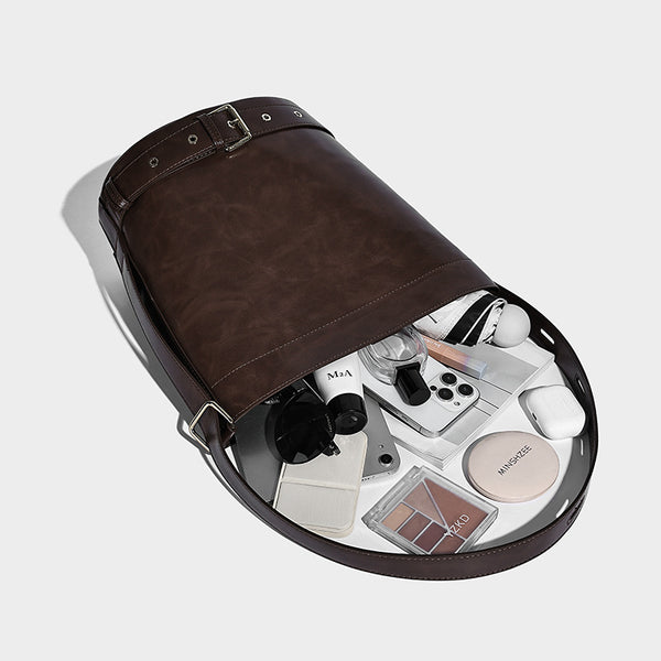 Glänzende Bucket-Bag in Lederoptik mit umlaufendem Riemen, silberfarbenen Ösen und verstellbarem Schulterriemen, Detailansicht 4