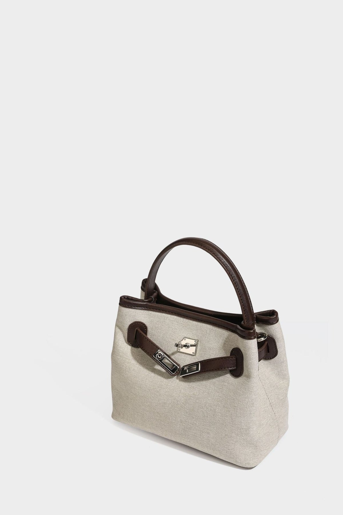 Small structured beige canvas top-handle bag with dark brown leather-look trim, silver turn-lock hardware, and detachable