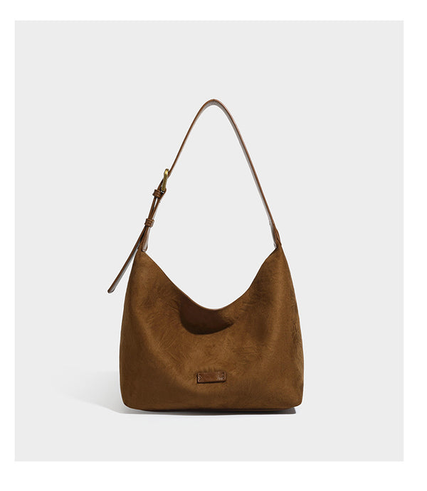 Dunkelbraune, lässig fallende Hobo-Schultertasche mit velourslederähnlich strukturierter Oberfläche, glatter lederähnlicher Paspelierung und Details in Antikgoldoptik, Detailansicht