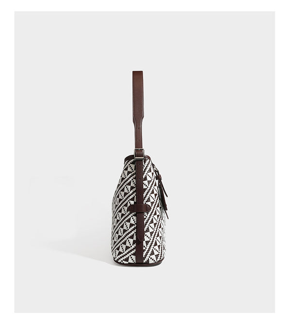 Woven geometric bucket shoulder bag in white and dark brown two-tone pattern with leather-look trim and drawstring top