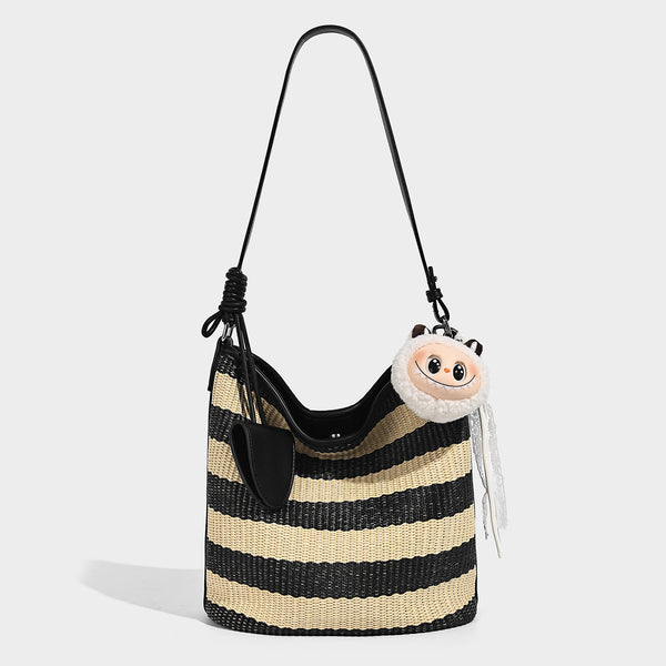 Gestreifte Webstoff-Beuteltasche in Schwarz und Beige mit schwarzem Besatz in Lederoptik, offenem oberen Rand und langem verstellbarem Schulterriemen, Detailansicht