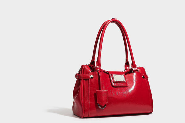 Structured glossy crinkled leather-look satchel with double top handles, front metal-plaque tab, silver-tone hardware, and