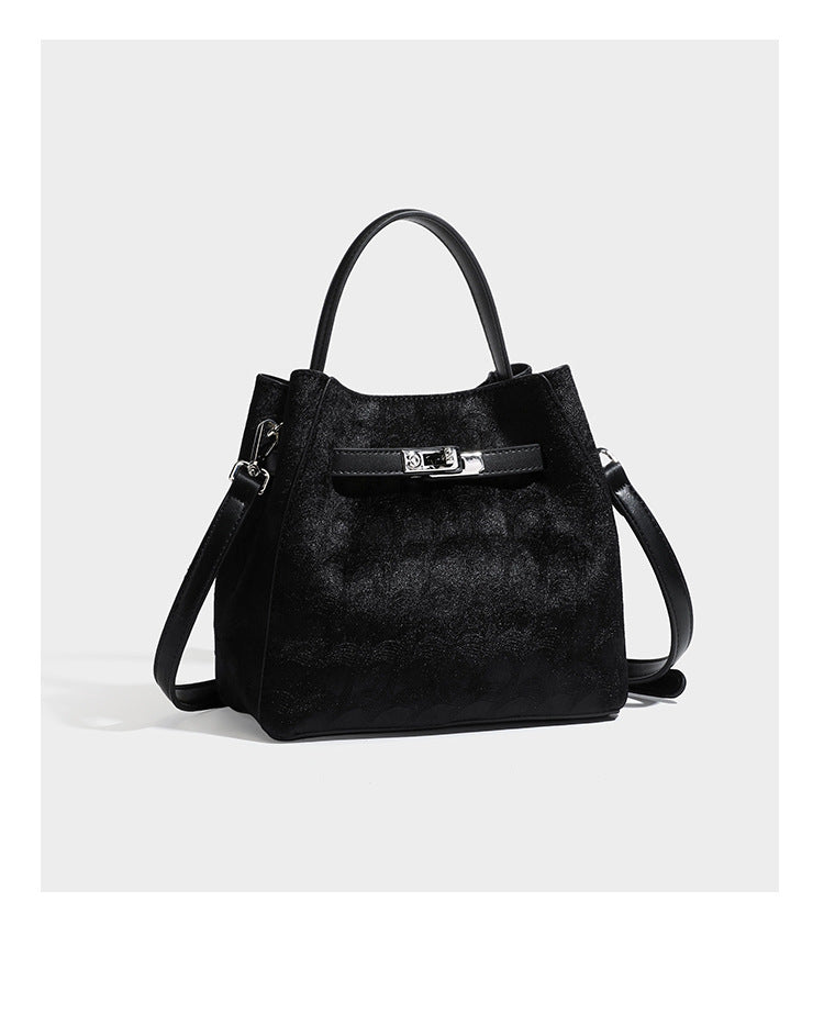 Small structured bucket satchel in embossed velvet-texture fabric with silver turn-lock hardware, rounded top handle, and