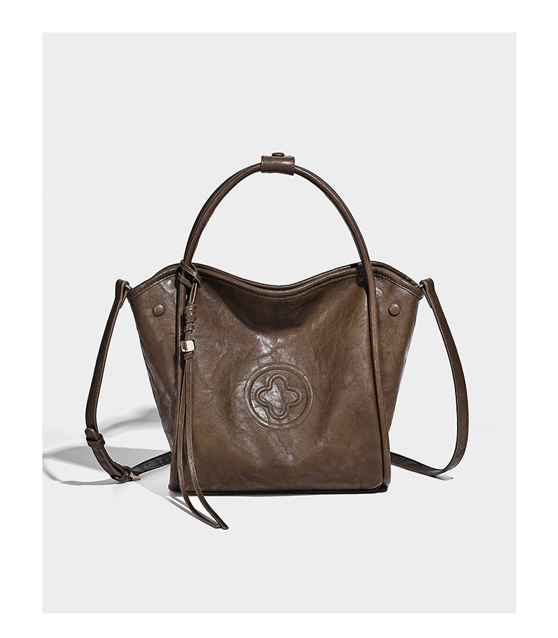 Glänzende Tote-Bag in geknautschter Lederoptik mit geprägtem rundem Emblem, Quastenschnürung, zwei Henkeln und abnehmbarem