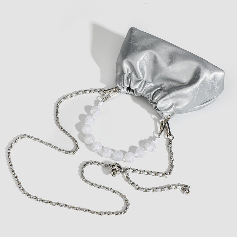 Small ruched drawstring pouch bag with pearl-bead handle and silver-tone chain strap, detail view 4