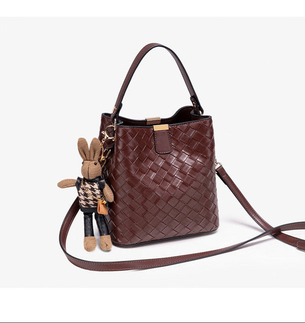 Brown woven-emboss leather-look bucket bag with short top handle, detachable crossbody strap, gold-tone hardware, and rabbit